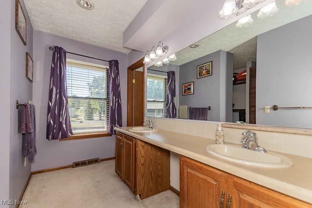 Dressing area featuring a double vanity, and lighting