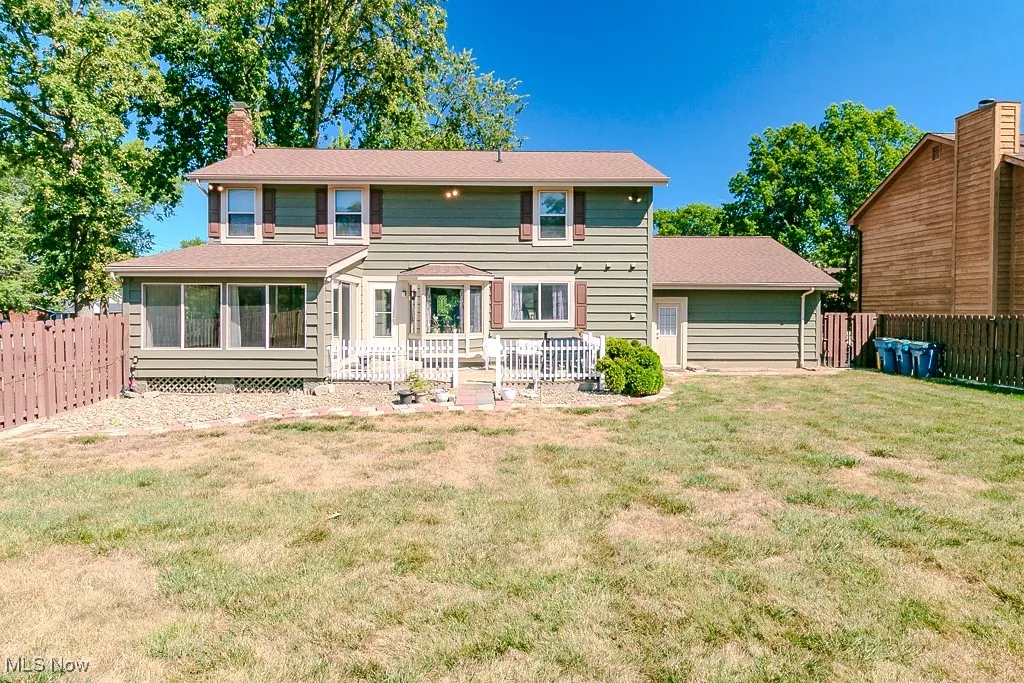 Back of property with a patio and sun room