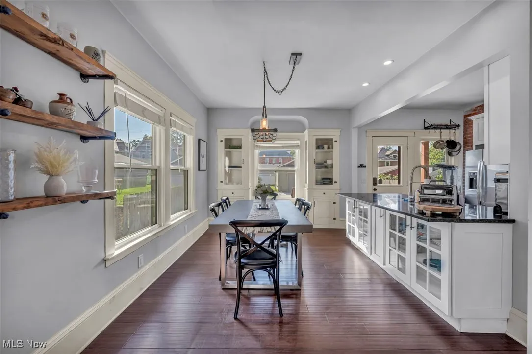 Dining space with healthy amount of natural light, dark wood-style flooring, and recessed lighting