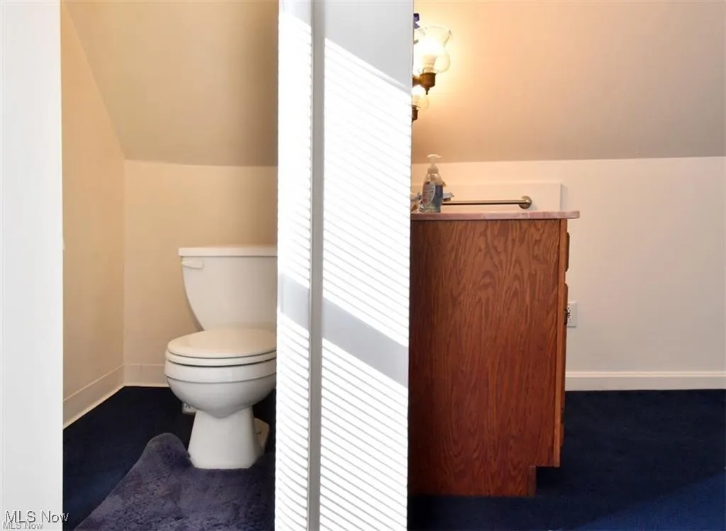 Bathroom with lofted ceiling and vanity