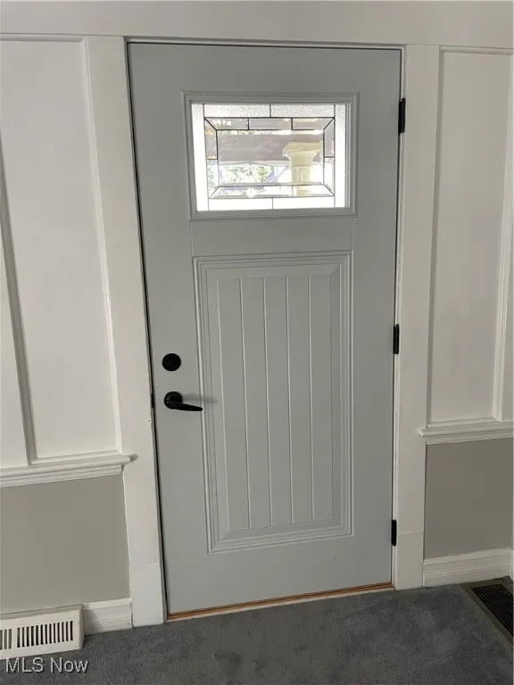 Doorway to outside featuring carpet flooring