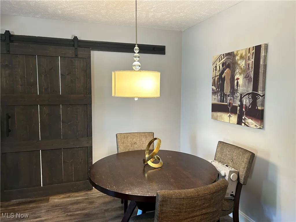 Dining space featuring a textured ceiling and wood finished floors
