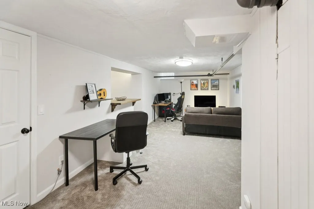 Rec Room with light colored carpet and a textured ceiling