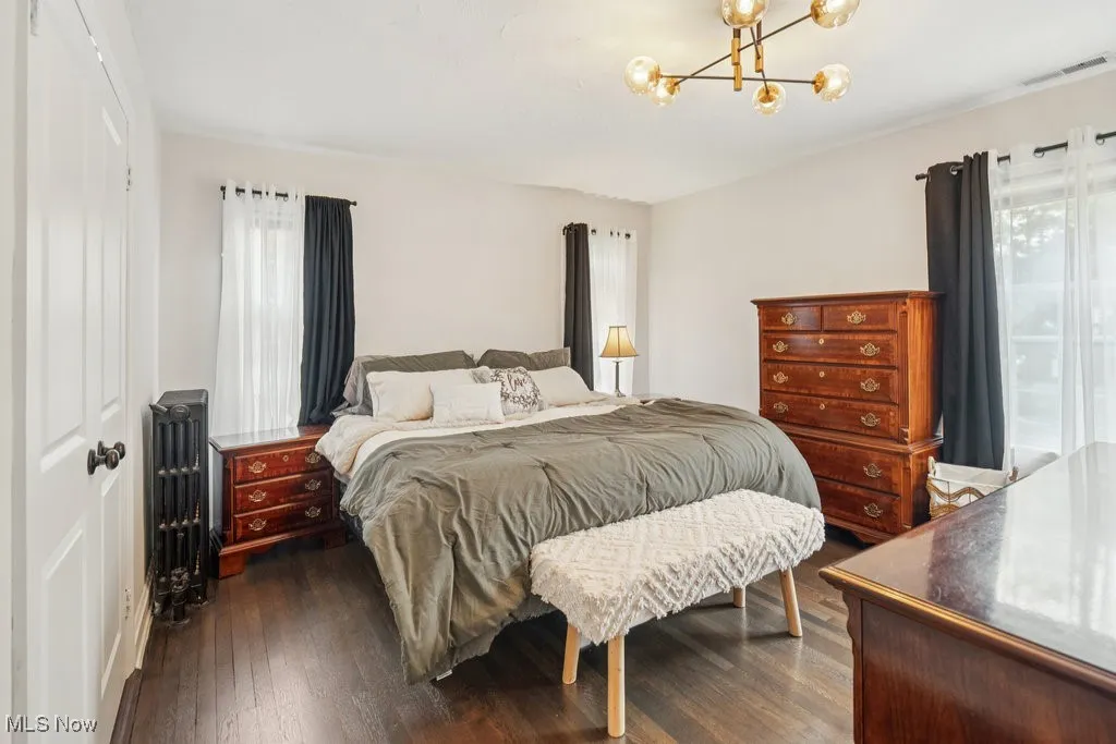 Master Bedroom featuring a closet, dark wood finished floors, a chandelier, and radiator