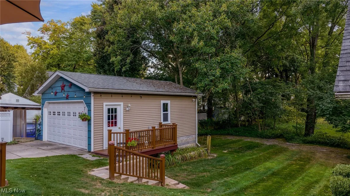 Detached garage featuring view of scattered trees