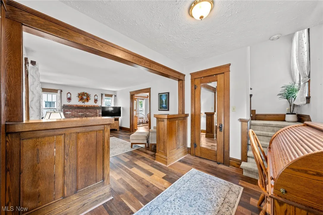 Foyer entrance featuring wood finished floors and a textured ceiling original Wood/lead glass door