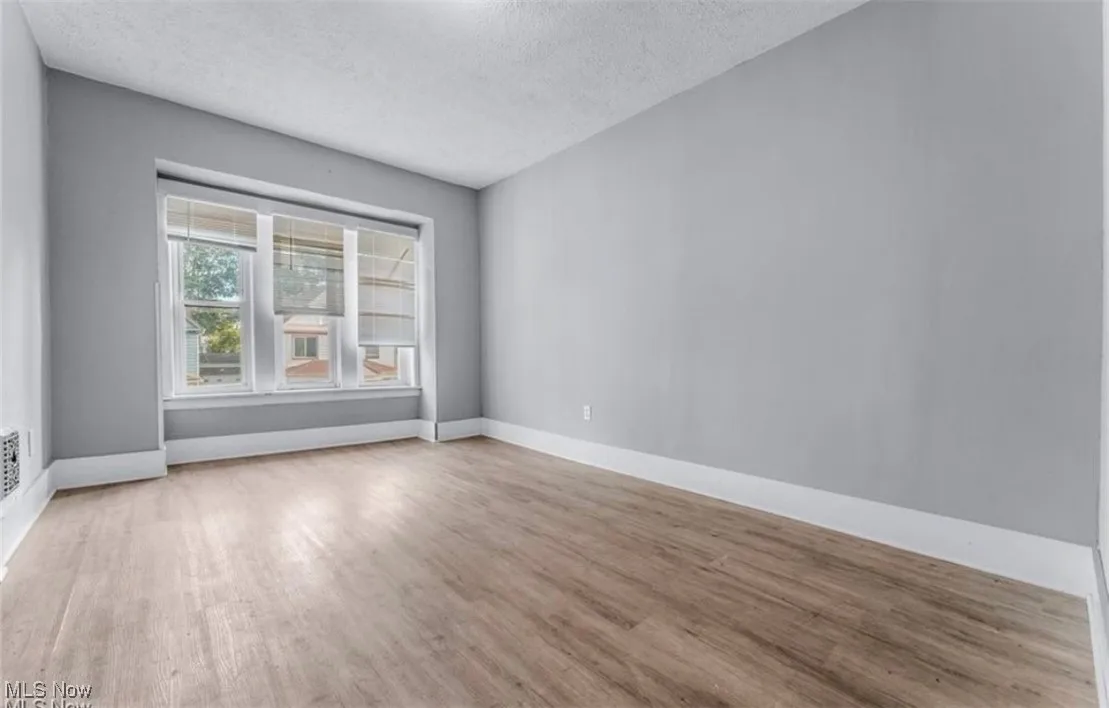 Empty room featuring a textured ceiling and light wood-style flooring