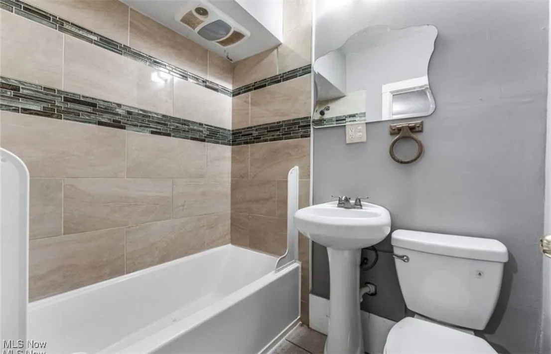 Bathroom with shower / tub combination and toilet