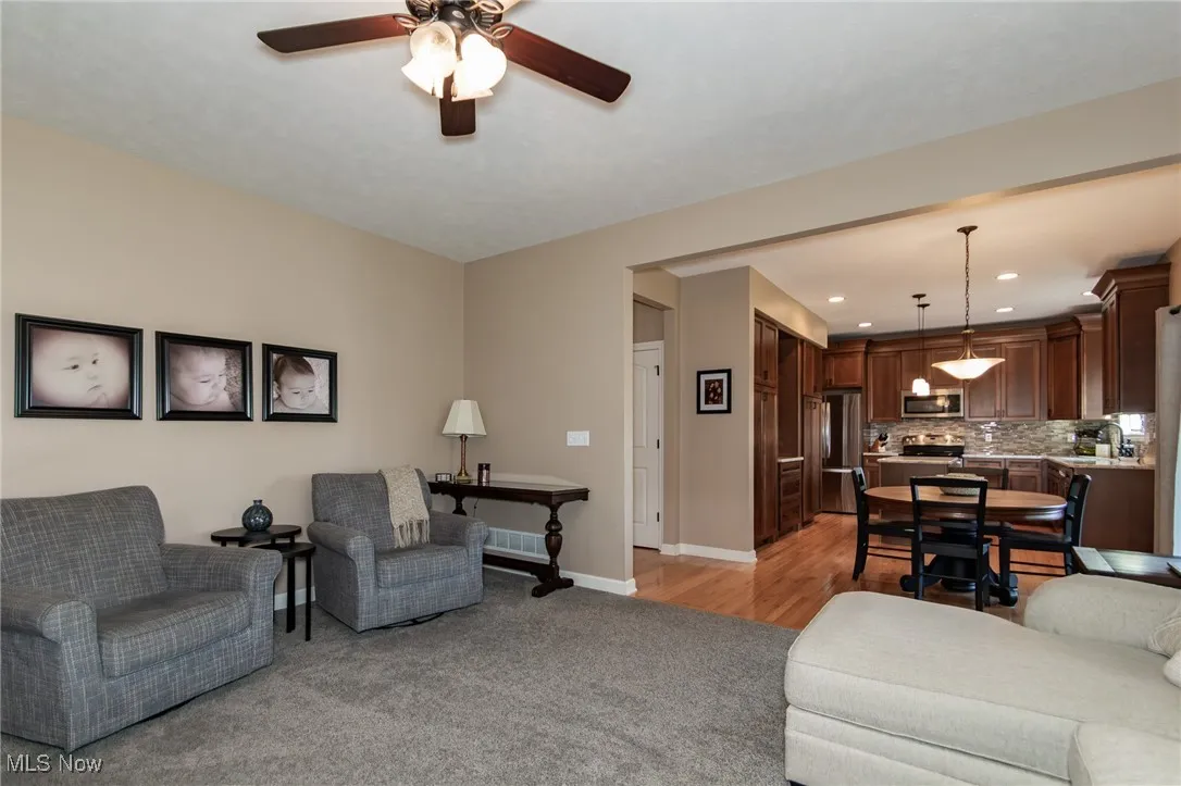 Living room featuring light colored carpet, a ceiling fan, and recessed lighting