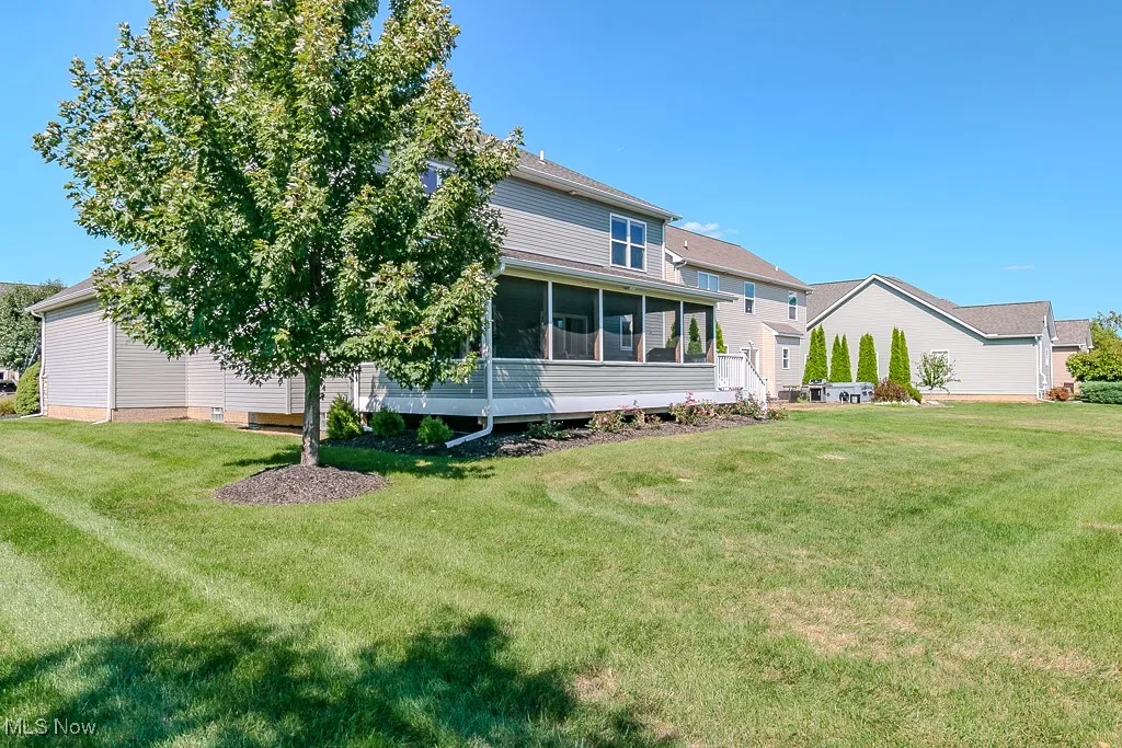 Back of house with a sunroom and a yard
