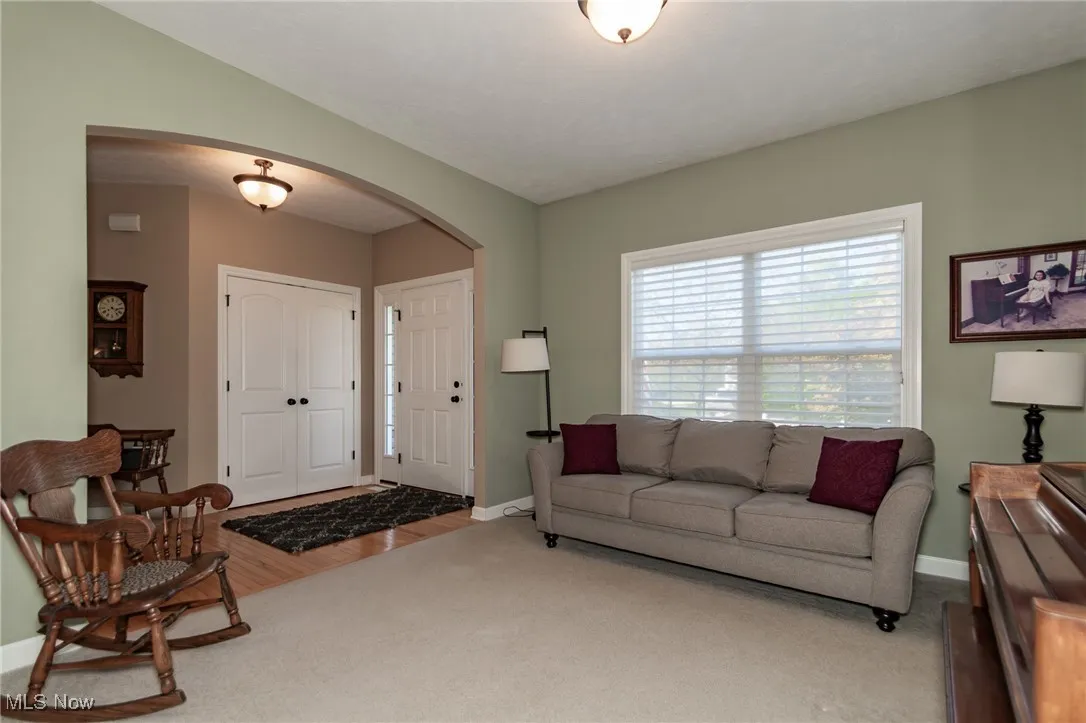 Living area featuring arched walkways and wood finished floors