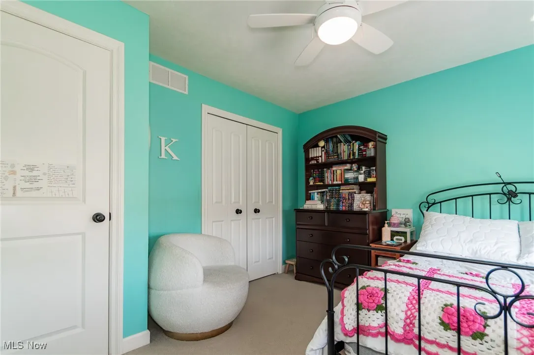 Carpeted bedroom featuring a closet and a ceiling fan