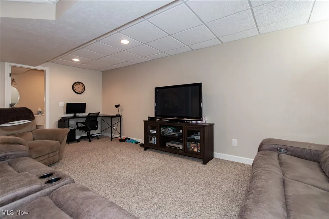 Carpeted living room with an office area, recessed lighting, and a drop ceiling