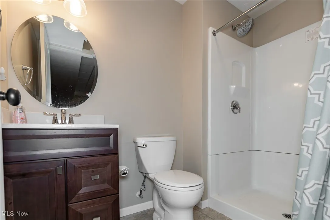 Bathroom featuring vanity, a stall shower, and light tile patterned flooring