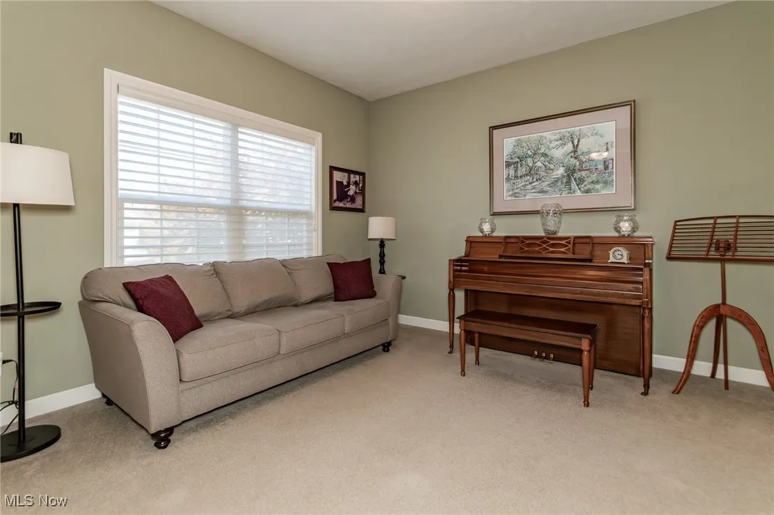 Living area with light carpet and baseboards