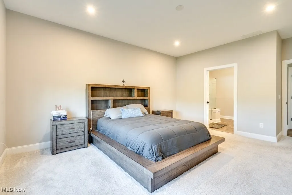 Carpeted bedroom featuring connected bathroom and recessed lighting