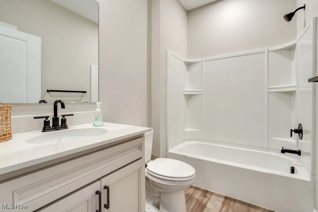 Bathroom with vanity, bathtub / shower combination, and light wood-style floors