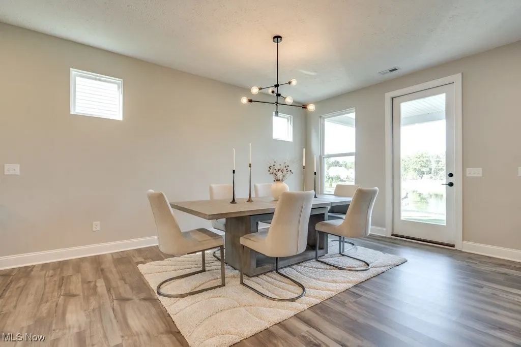 Dining area with light wood-type flooring and a chandelier