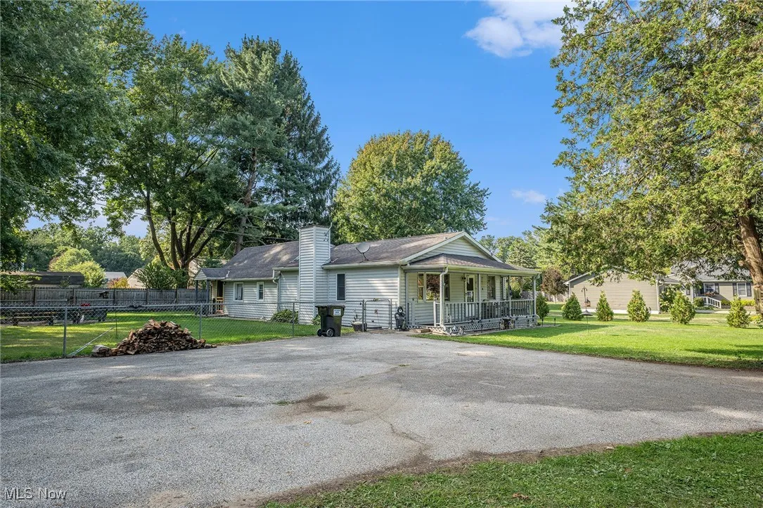 View of front facade with a porch, a front lawn, and a chimney