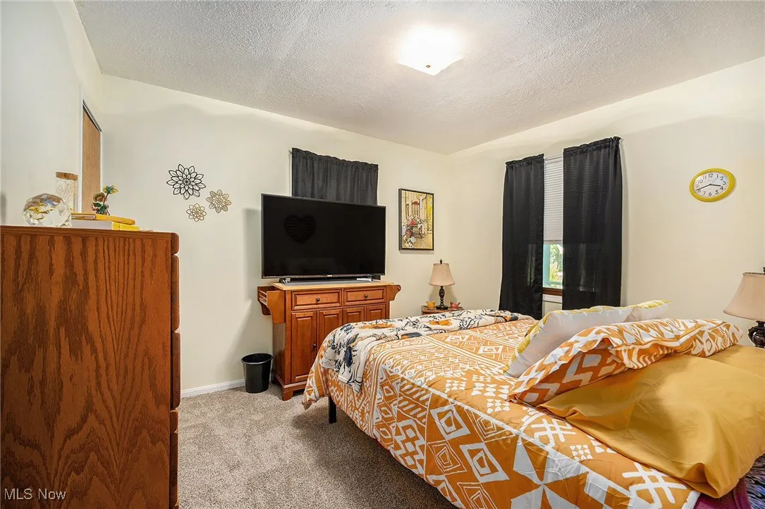 Bedroom featuring light carpet and a textured ceiling