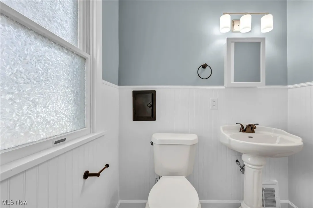 Bathroom with a wainscoted wall and toilet