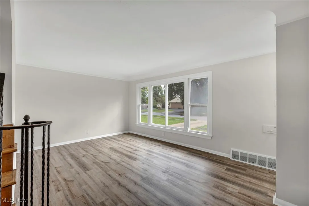 Empty room with light wood finished floors and ornamental molding