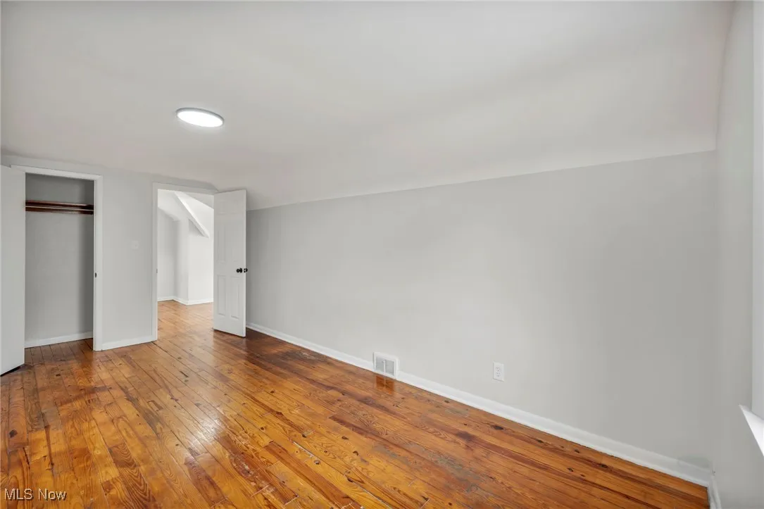 Unfurnished bedroom with hardwood / wood-style floors and a closet