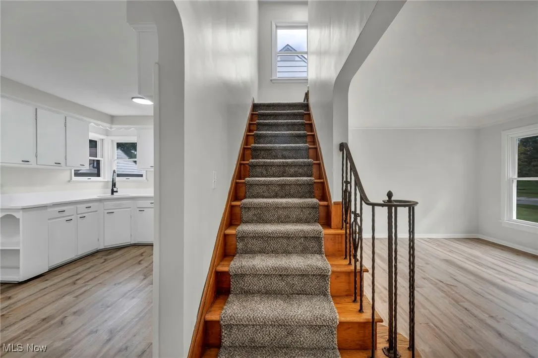 Stairs with wood finished floors and arched walkways
