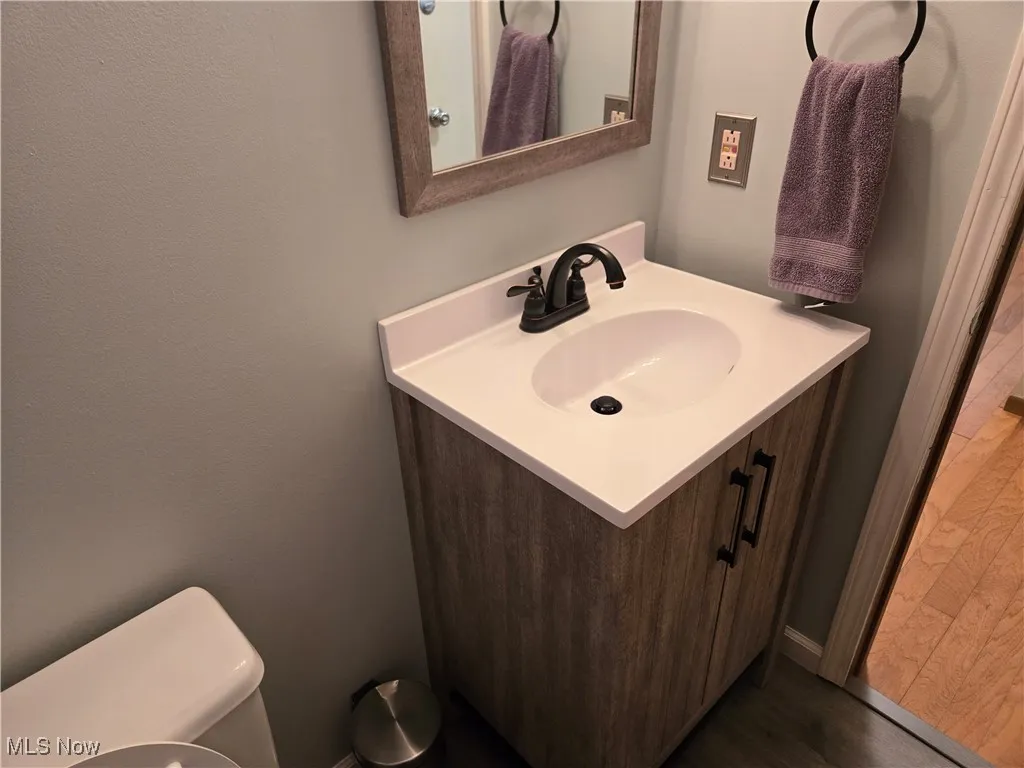 Bathroom featuring vanity, dark wood-style flooring, and a textured wall