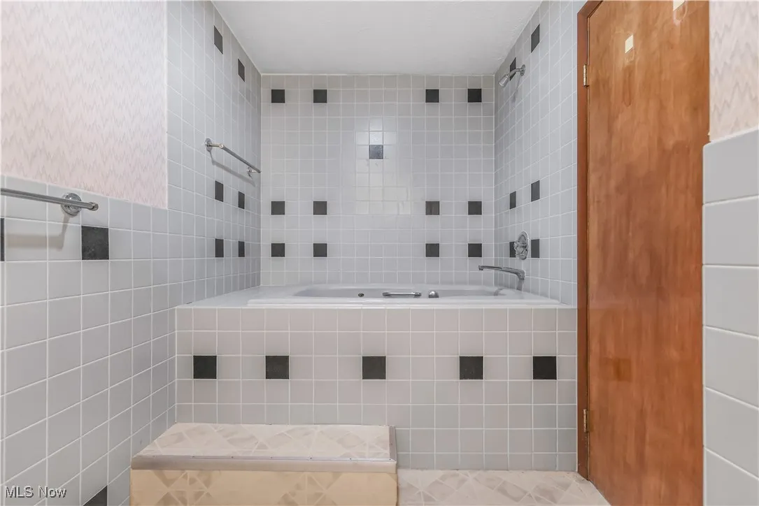 Full LL bathroom featuring tile walls and jacuzzi tub