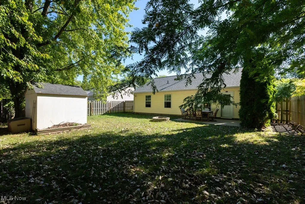 Fenced backyard featuring a patio and a shed