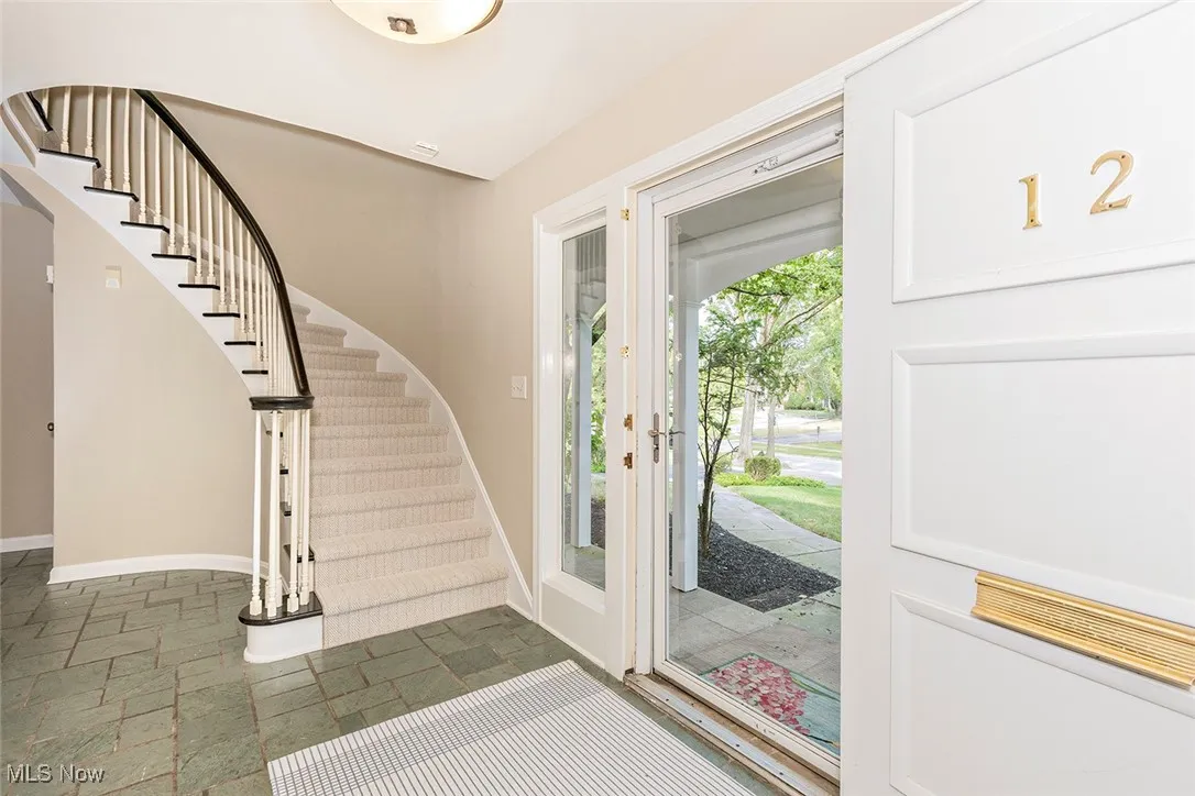 Foyer with stairway and stone tile flooring