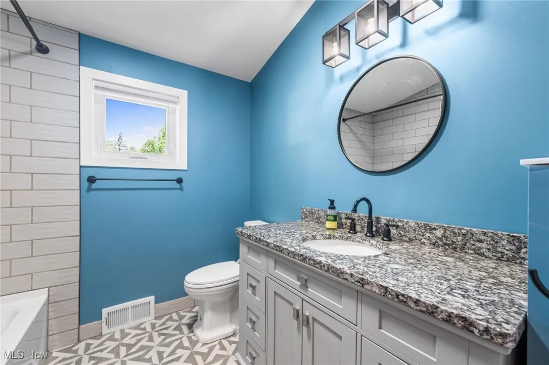 Full bathroom on second floor with granite counters, subway tile shower and soft close cabinetry.