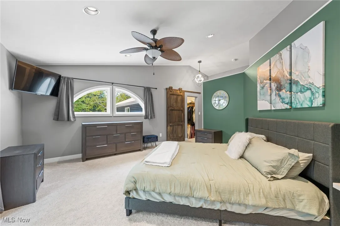 Primary bedroom with ample natural light featuring walk-in closet with barn door.