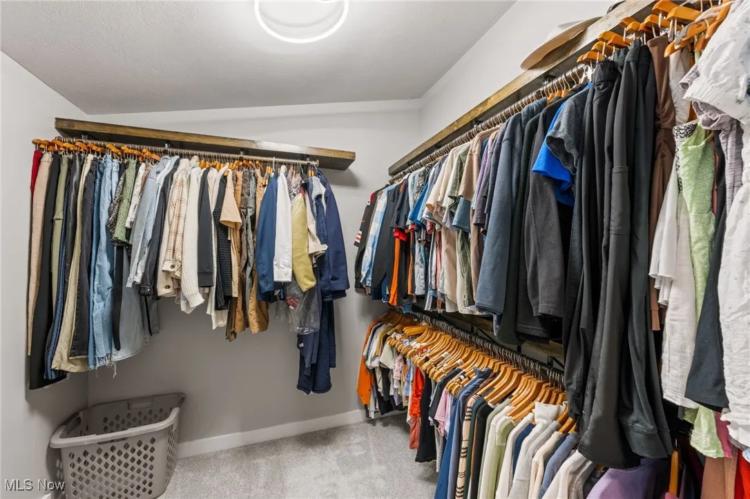 Walk-in Closet in primary suite with custom clothing racks.