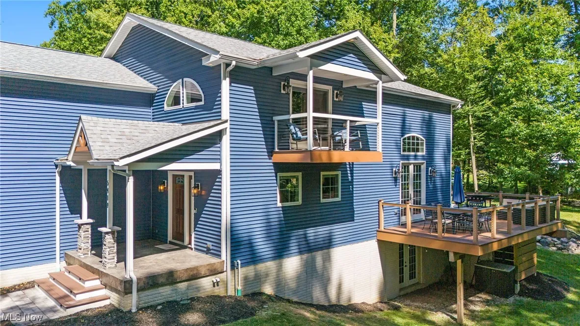 View of the side of house with balcony and lower wrap around deck.