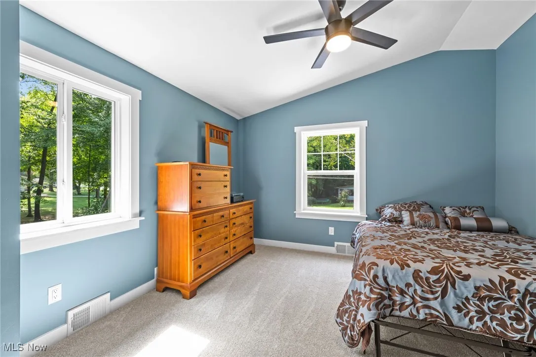 Additional secondary bedroom with large windows and vaulted ceiling.