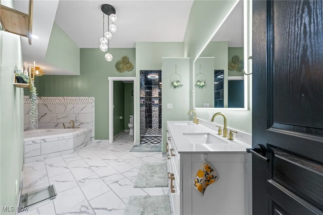 Spa-like sanctuary in this ensuite primary bathroom with jetted soaking tub, dual sink vanity with Smart LED light mirror.
