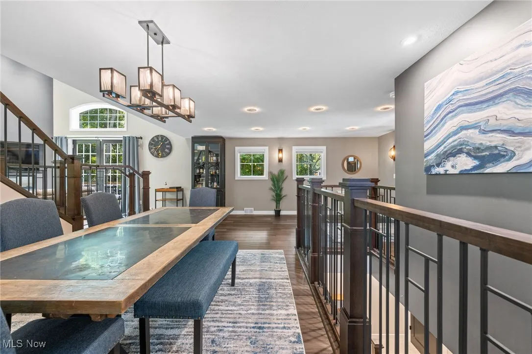 Dining area framed by staircases to upper and lower floors.
