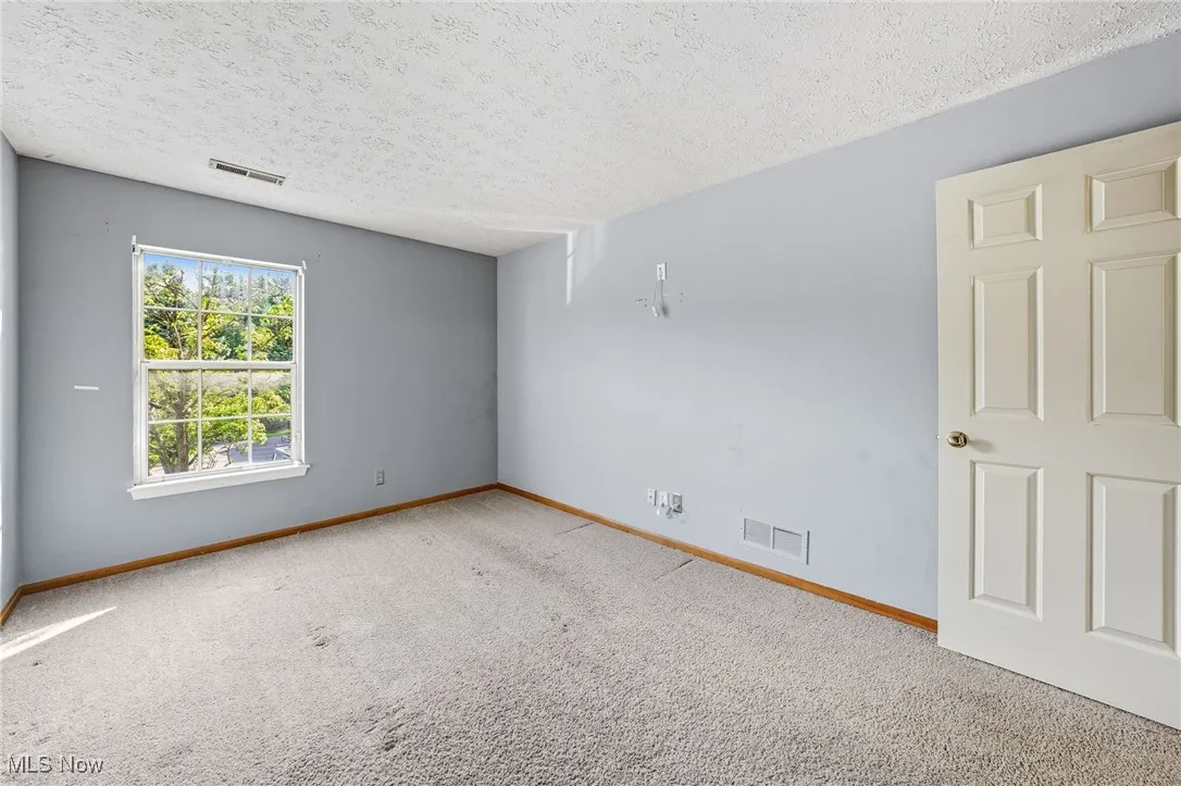 Spare room with carpet flooring and a textured ceiling