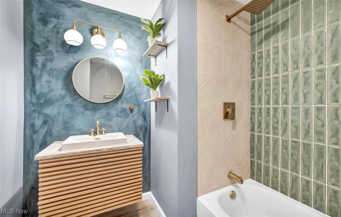 Bathroom featuring shower / washtub combination, vanity, and wood finished floors