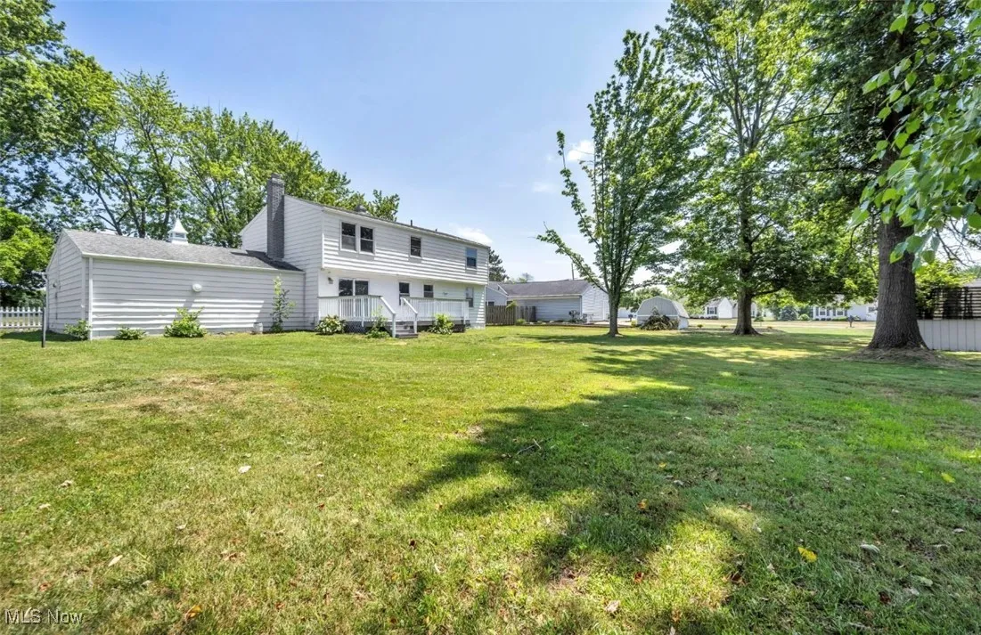 Back of property with a yard and a chimney