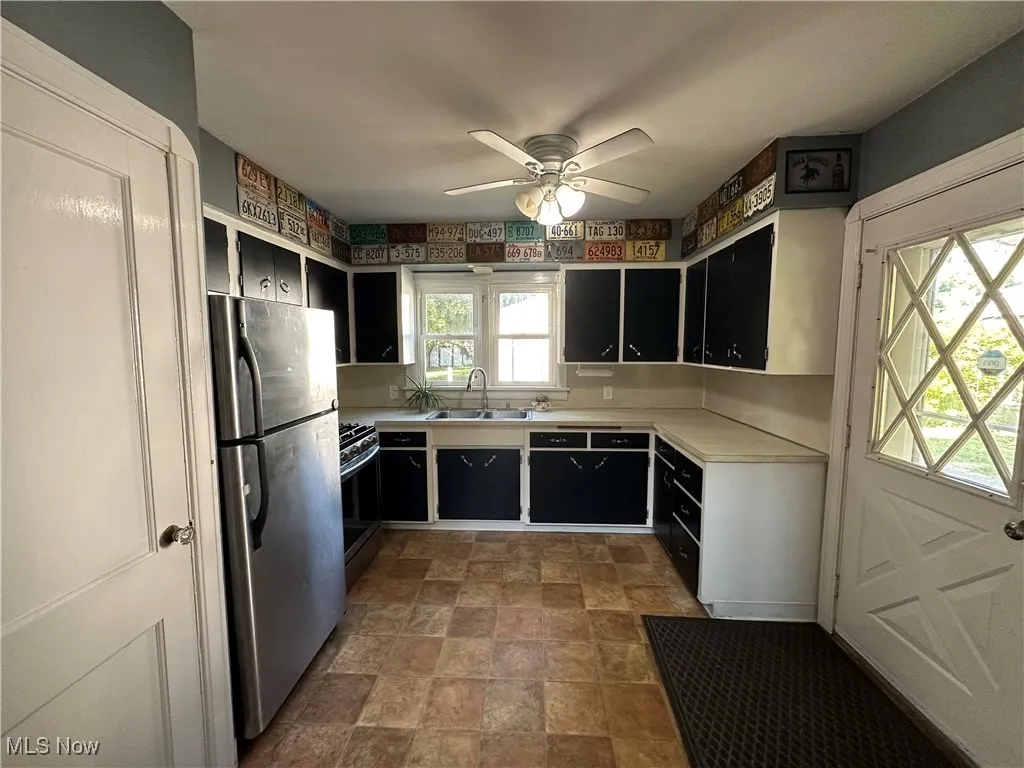 Kitchen has plenty of cabinet space and countertops. Door to the basement is on the left and door to side porch is on the right.