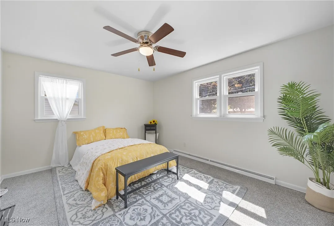 Bedroom featuring a baseboard radiator, carpet flooring, and ceiling fan