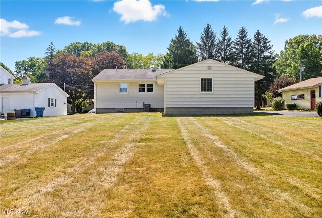 Rear view of property featuring a lawn and crawl space
