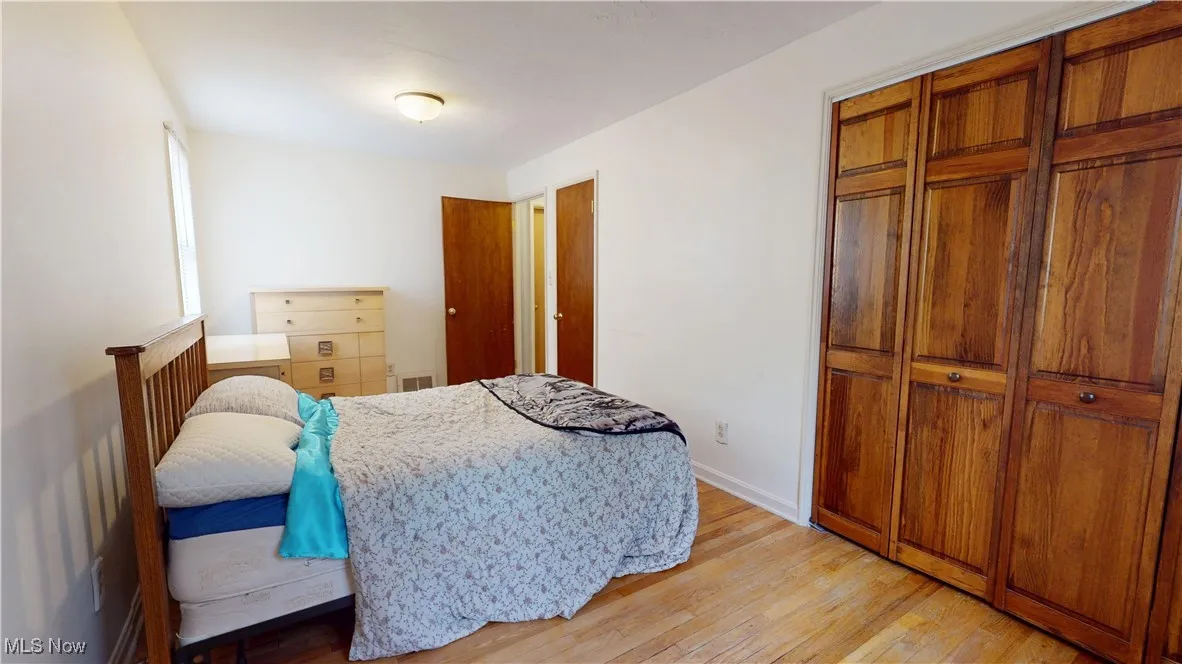 Bedroom with light wood finished floors and a closet