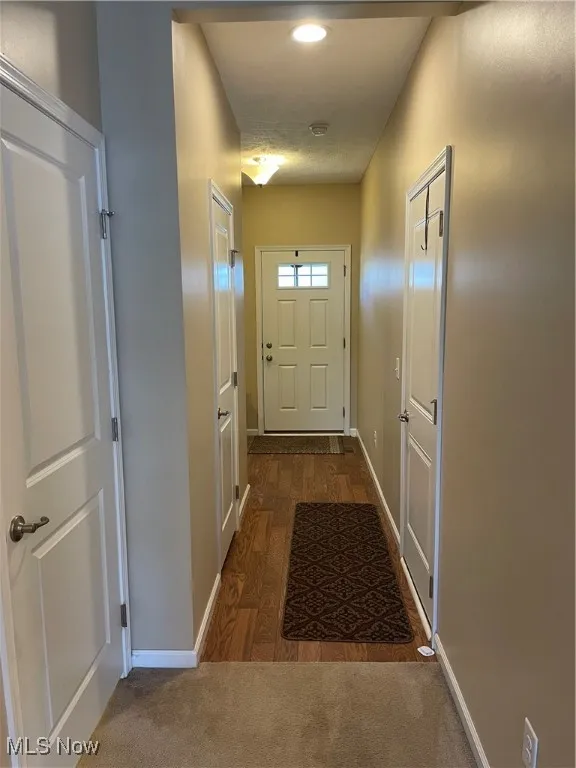 Doorway to outside featuring wood finished floors and carpet flooring