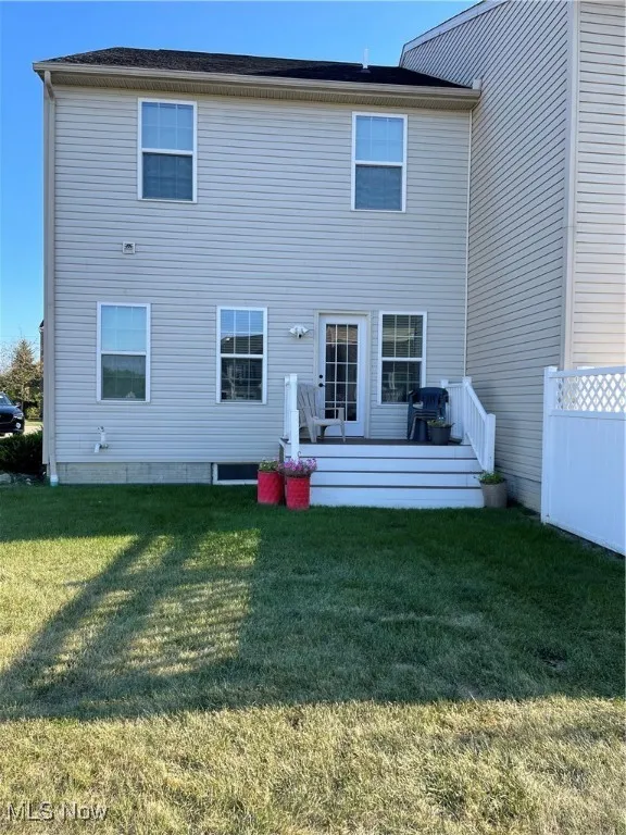 Back of house with a lawn and a wooden deck