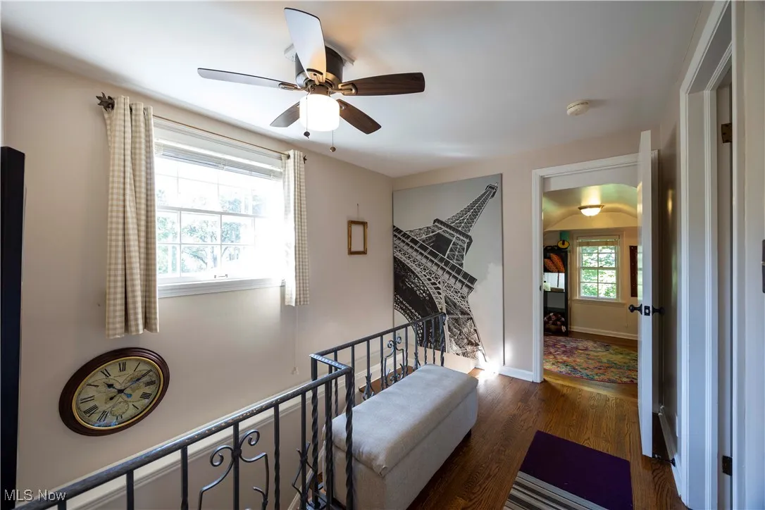 Stairway featuring wood finished floors and a ceiling fan