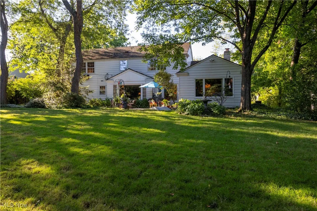 Rear view of house with a yard and a chimney